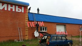 Подъем вывески на крышу здания